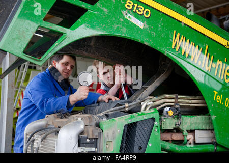 Formazione pratica per la meccatronica. Insegnamento istruttore spiega un trattore. Foto Stock