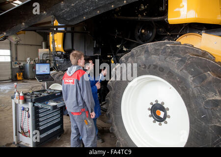 Formazione pratica per la meccatronica. Insegnamento istruttore spiega una mietitrebbia. Foto Stock