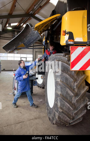 Formazione pratica per la meccatronica. Insegnamento istruttore spiega una mietitrebbia. Foto Stock