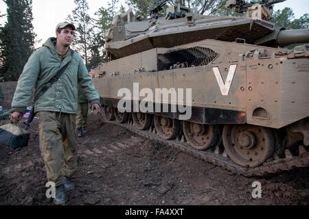 Gerusalemme, Medio Oriente. Il 21 dicembre, 2015. Un soldato israeliano passa un serbatoio Merkava distribuito nei pressi del confine israelo-palestinese, 21 dicembre 2015. Tre razzi sono stati sparati dal Libano in Israele la regione nordoccidentale domenica, ore seguenti l'apparente assassinio di un top Hezbollah libanesi leader militare. Credito: Xinhua/Alamy Live News Foto Stock