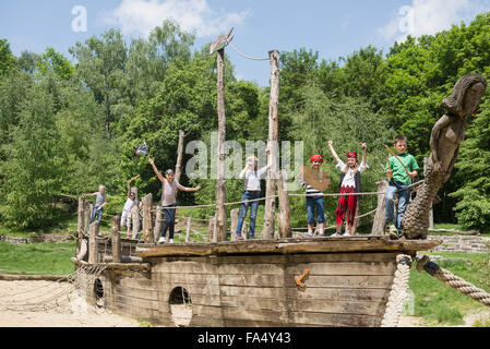 Un gruppo di bambini che giocano su una nave pirata nel parco giochi avventura, Baviera, Germania Foto Stock