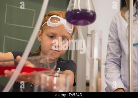 School girl liquido di miscelazione in chimica classe, Fürstenfeldbruck, Baviera, Germania Foto Stock