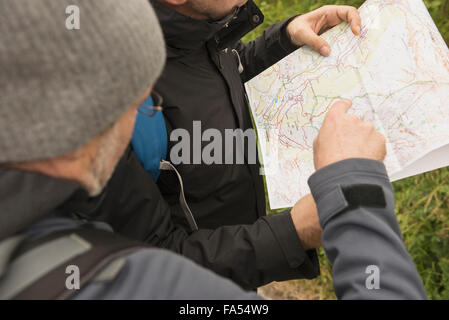 Due escursionisti matura il controllo della mappa per il modo giusto, Alpi austriache, Carinzia, Austria Foto Stock