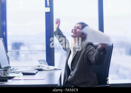 Emozionato imprenditrice celebra il suo successo in un ufficio di Freiburg im Breisgau, Baden-Württemberg, Germania Foto Stock