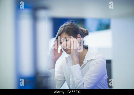 Donna d'affari che soffre di mal di testa in un ufficio, Friburgo Im Breisgau, Baden-Württemberg, Germania Foto Stock