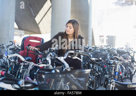 Giovane donna parcheggio la sua bicicletta, Freiburg im Breisgau, Baden-Württemberg, Germania Foto Stock