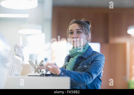 Ritratto di una donna matura in attesa alla reception dell'albergo, Freiburg im Breisgau, Baden-Württemberg, Germania Foto Stock