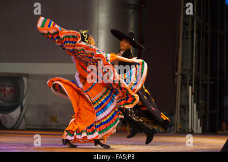 Ballerino femmina in colorate arancio ripetutamente il vestito di torsione e svolazzanti bracci durante il Mexican Hat dance, folclore tradizionale Foto Stock