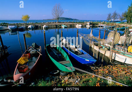 Piccolo porto di San Feliciano con tradizionali barche da pesca (sullo sfondo Isola Polvese), Lago Trasimeno, Umbria, Italia Foto Stock