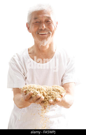 Il vecchio gli agricoltori tenendo il riso Foto Stock