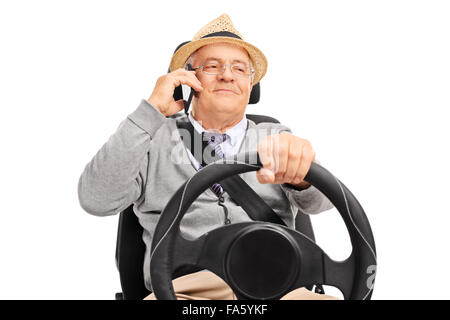 Senior uomo fingendo di guidare un auto e parlare al telefono cellulare isolato su sfondo bianco Foto Stock