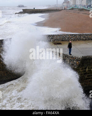 Brighton Sussex Regno Unito 22 Dicembre 2015 - Un uomo orologi le onde in crash presso il molo sul bagnato e condizioni meteorologiche ventose sul lungomare di Brighton oggi Credito: Simon Dack/Alamy Live News Foto Stock