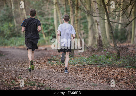 Due corridori esercizio a Thorndon Parco bosco in Essex, Inghilterra, Regno Unito. Foto Stock