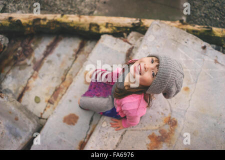 Vista in elevazione della ragazza seduta sul passo indossando hat Foto Stock