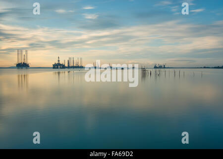 Cielo drammatico e silhouette di jack up rig in mattina presto Foto Stock