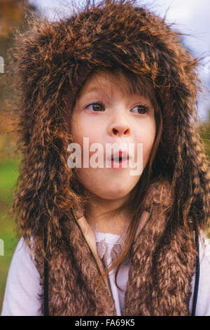 Ritratto di giovane ragazza in soffici hat facendo una faccia buffa Foto Stock