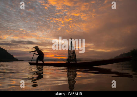 Silhouette di un uomo la pesca in lago, Thailandia Foto Stock