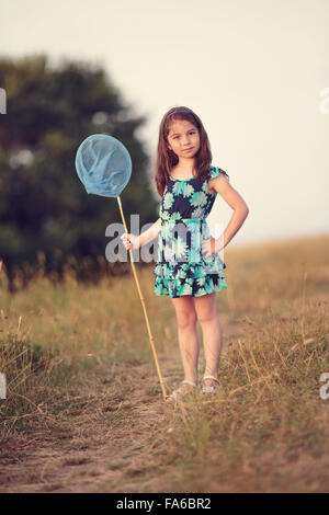 Ragazza in piedi all'aperto con una rete di farfalle, Sinemorets, Burgas, Bulgaria Foto Stock