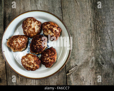 Fritti di polpette di carne su una piastra su un tavolo di legno Foto Stock