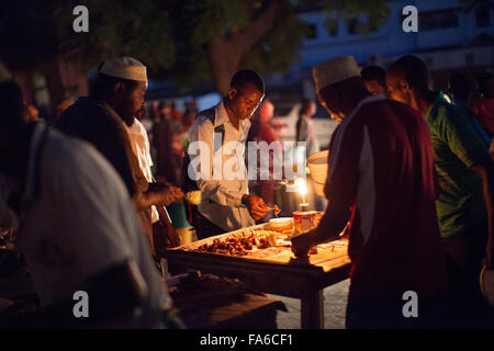 I venditori di strada che utilizzano lampade a cherosene durante un blackout in Stone Town, Zanzibar, Tanzania. Foto Stock