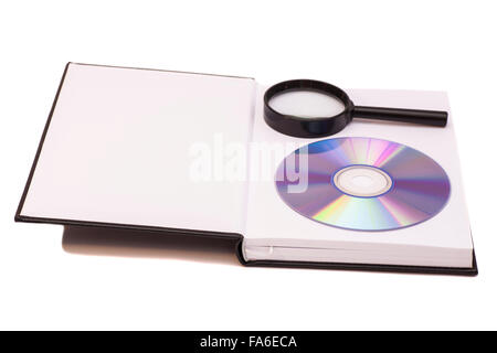 Libro aperto con lente di ingrandimento e compact disk CD Foto Stock