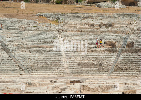 Vacanza giovane coppia, vista di una giovane coppia turistica a piedi nell'antico teatro greco nel Parco Archeologico, Siracusa, Sicilia. Foto Stock