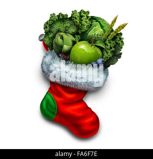 Sana vacanza mangiare e anno nuovo dieta risoluzione come un gruppo di verdura e frutta fresca in un rosso calza di Natale come un simbolo di festa di un dono vegetariano o inverno icona fitness. Foto Stock