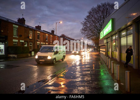 Asda mini store su Gorton Lane di notte strada wet weather pozzanghere serale per crepuscolo alba insegne al neon riflessioni lampioni Foto Stock