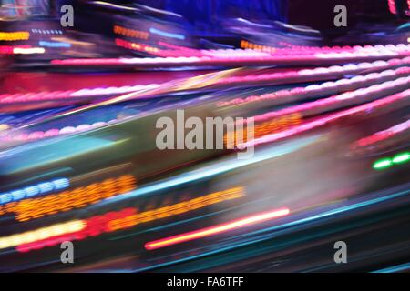 Fiera luna park ride movimento veloce fiera notte luci di colori del parco dei divertimenti di luci in movimento, sentieri di luce, lenta velocità otturatore Foto Stock