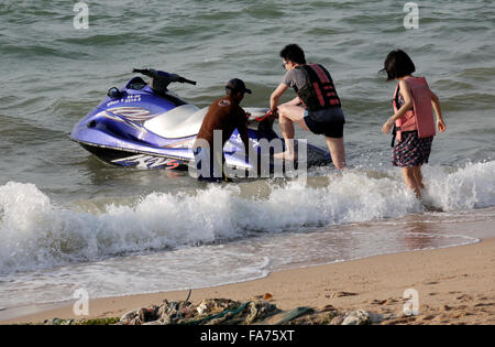 Una giovane coppia di assunzione e di salire a bordo di un jetski sulla spiaggia di Pattaya in Thailandia Foto Stock