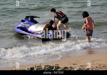 Una giovane coppia di assunzione e di salire a bordo di un jetski sulla spiaggia di Pattaya in Thailandia Foto Stock