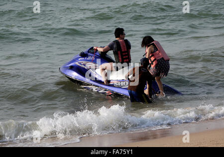 Una giovane coppia di assunzione e di salire a bordo di un jetski sulla spiaggia di Pattaya in Thailandia Foto Stock