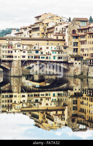 Ponte Vecchio e gli edifici storici sono rispecchiati nel fiume Arno, Firenze, Toscana, Italia. Destinazione di viaggio. Foto Stock