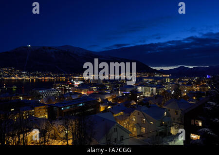 Tromso city in inverno nevoso notte con luce,traffico,fjord e movimento con il continente in background Foto Stock