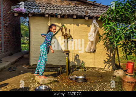 Giovani nepalesi ragazza prende l'acqua da un pozzo nel villaggio Foto Stock