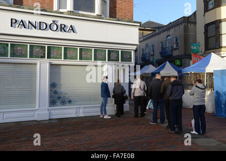 Christmas Shopper coda fuori un negozio di Pandora in attesa di aprire in Worthing West Sussex, in Inghilterra. Foto Stock