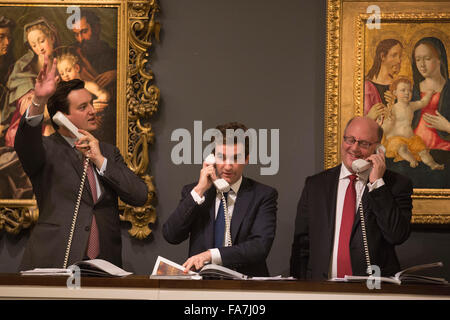 Gli agenti di vendita tenendo il telefono offerte. L'asta di dipinti dal Vecchio Maestro & British dipinti sera la vendita avviene a Sotheby's New Bond Street, Londra. Foto Stock