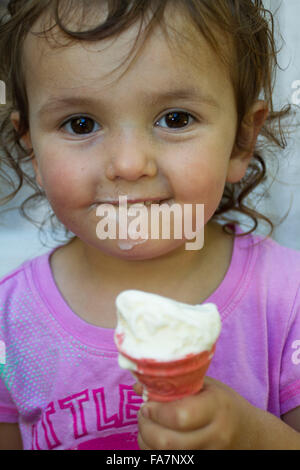 Il Toddler ragazza con faccia sporca gode di gelato Foto Stock