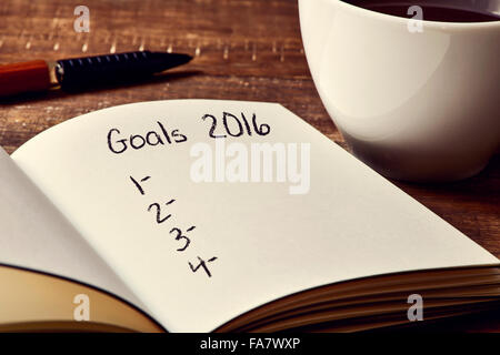 Primo piano di un notebook con un elenco vuoto di obiettivi per il 2016 e una tazza di caffè su una tavola in legno rustico Foto Stock