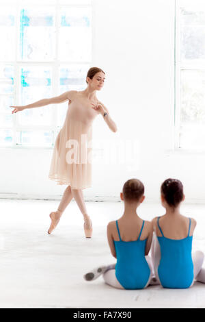 Due piccoli ballerini danzano con personale insegnante di balletto in studio di danza Foto Stock