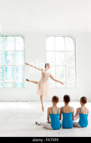 Tre piccoli ballerini danzano con personale insegnante di balletto in studio di danza Foto Stock