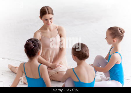 Tre piccoli ballerini danzano con personale insegnante di balletto in studio di danza Foto Stock