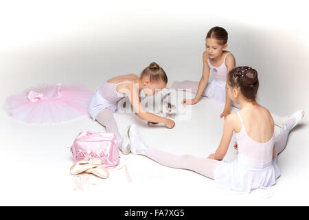 Tre piccoli balletto delle ragazze seduto e in posa insieme Foto Stock