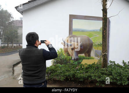 Huzhou, cinese della Provincia di Zhejiang. 23 Dic, 2015. Un turista prende la foto di un 3D murale nel villaggio Hengshanwu, Contea di Anji, est della Cina di Provincia dello Zhejiang, Dic 23, 2015. © Zhang Hui/Xinhua/Alamy Live News Foto Stock