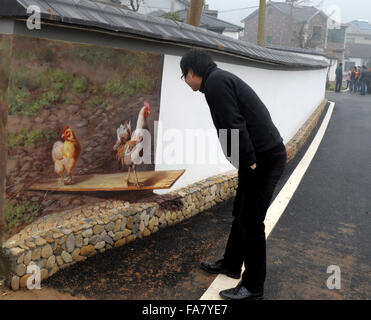 Huzhou, cinese della Provincia di Zhejiang. 23 Dic, 2015. Un turista guarda un 3D murale nel villaggio Hengshanwu, Contea di Anji, est della Cina di Provincia dello Zhejiang, Dic 23, 2015. © Zhang Hui/Xinhua/Alamy Live News Foto Stock