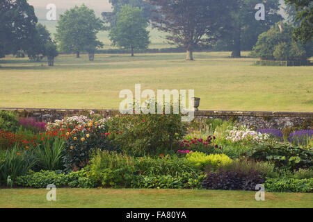 Piante erbacee terrazza a Killerton, Devon nel luglio mostra le rose, lavanda, crocosomia, dalie, urne cinerarie e parco al di là. La terrazza è stata suggerita da architetto Henry Protheroe nel 1900 e completato per le raccomandazioni di William Robinson nel 1905. Foto Stock