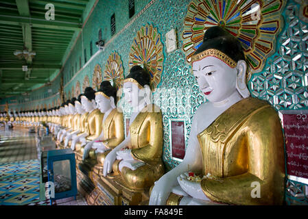 U min Thonze Pagoda statue di Buddha Sagaing Myanmar // SAGAING, Myanmar — Una fila curva di statue di Buddha si trova nella sala principale della Pagoda di U min Thonze (nota anche come Pagoda OoHminThoneSel), disposte nella caratteristica formazione a mezzaluna del tempio. La pagoda ospita 45 immagini uniche di Buddha che rappresentano i 45 anni di insegnamenti buddisti, costruite nella collina di Sagaing in un tempio artificiale ibrido. Originariamente fondata da re Tarabya i tra il 1327 e il 1335, l'attuale struttura risale alla ricostruzione di re Pagan min completata nel 1847 in seguito al devastante terremoto di Ava del 1839. U min Tho Foto Stock