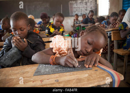 Gli studenti utilizzano piccole lavagne di ardesia a Kouka scuola primaria nel Dipartimento Kouka, Burkina Faso. Foto Stock