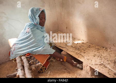 Una donna può contenere uova fresche previste dai suoi polli di Tengréla Village, Burkina Faso. Foto Stock
