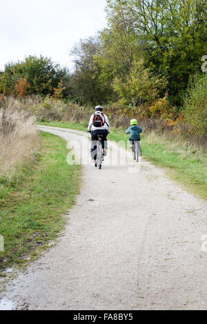 Un padre e figlio fuori per un giro sulle loro moto lungo una traccia Foto Stock